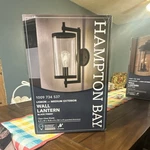 Hampton Bay Lisbon Medium Exterior Wall Lantern Black Finish Clear Glass Shade. Fixed Price $30.00.