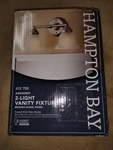 Hampton Bay Brushed Nickel Ashhurst 2 Light Vanity Fixture 16.1"X 7.3"X 9.1". Fixed Price $13.99.