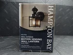 Hampton Bay 9.5IN 1-LIGHT Farmhouse Motion Sensing Outdoor Wall Lantern. Fixed Price $27.99.